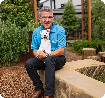 Brad Smith - CEO, RSPCA Pet Insurance sitting with a dog