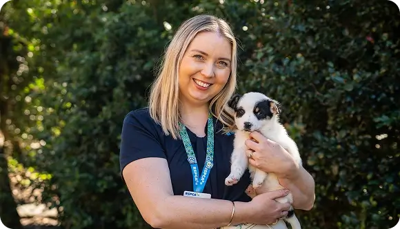 RSPCA representative holding a puppy